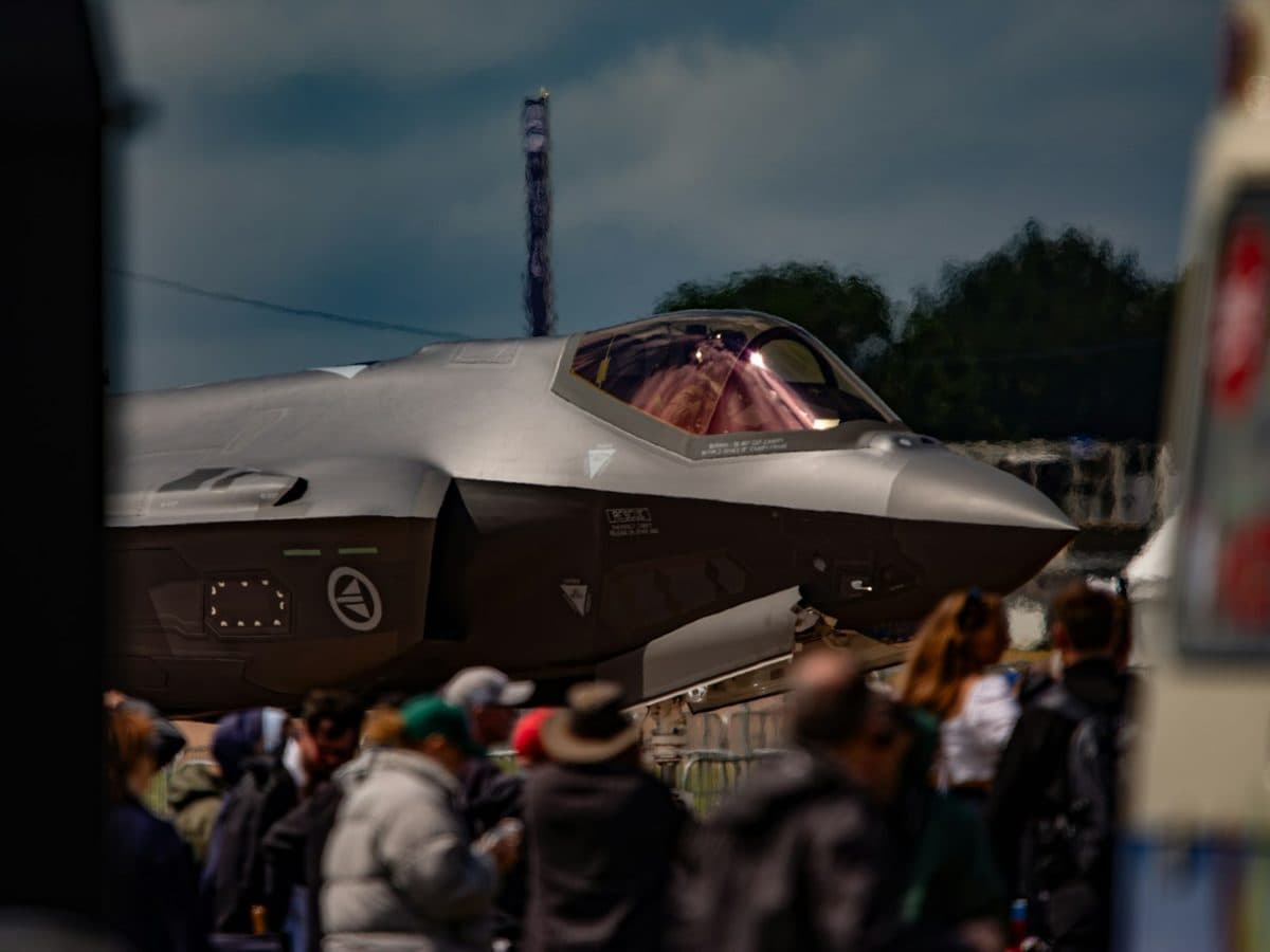 Spectators looking up at a fighter jet on static display