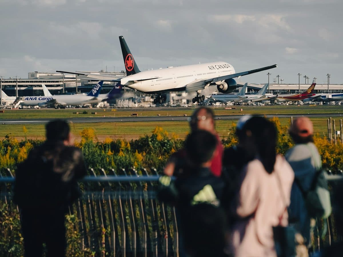 Crowd of spectators watching an airliner on the runway